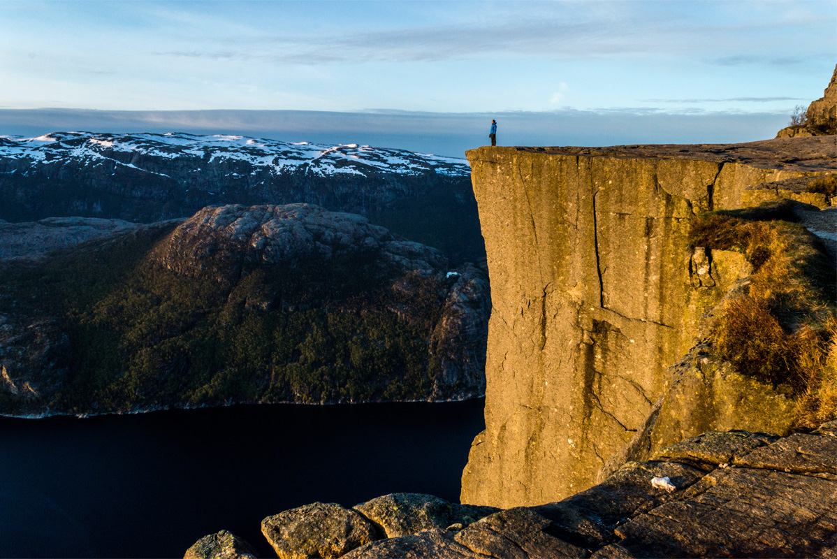 A person enjoying the sunrise on the flat and very tall pulpit rock.
